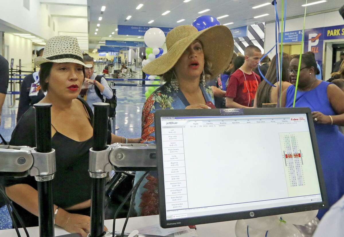Michelle Sanchez-Boyce, left, and Erika Munro Kennerly, of New york, check in at the JetBlue counter to travel to Santa Clara, Cuba on Aug. 31, 2016, at the Fort Lauderdale-Hollywood International Airport in Fort Lauderdale, Fla. The first commercial flight between the United States and Cuba in more than a half century flew out of Fort Lauderdale for the central city of Santa Clara on Wednesday morning, re-establishing regular air service severed at the height of the Cold War.