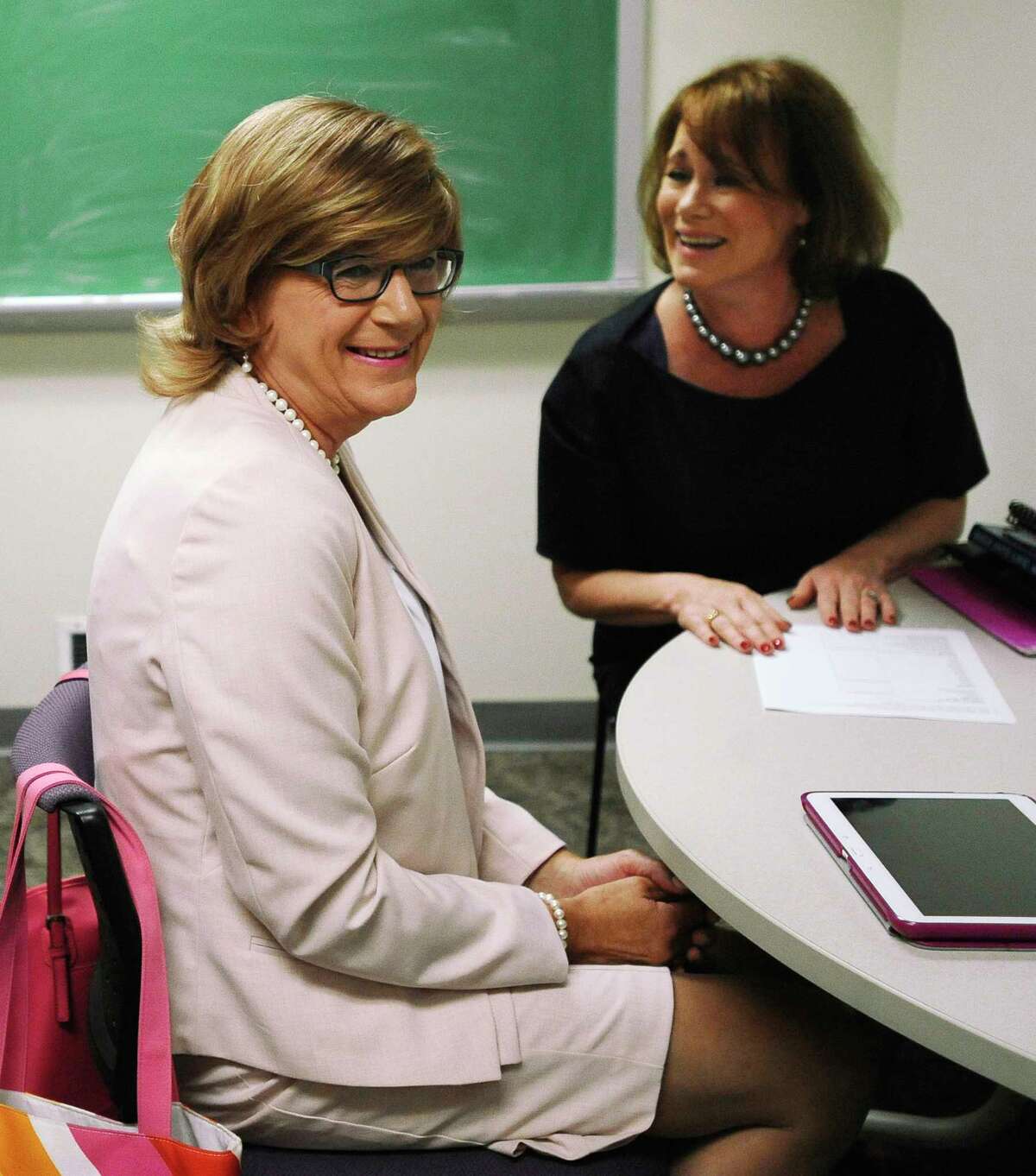 In this July 22, 2015, photo, Brianne Roberts, left, smiles as she works on voice exercises with speech-language pathologist Jean McCarthy, right, at the University of Connecticut’s Speech and Hearing Clinic in Storrs, Conn. Roberts is in a program at UConn that teaches transgender people how to sound more like the sex with which they identify.