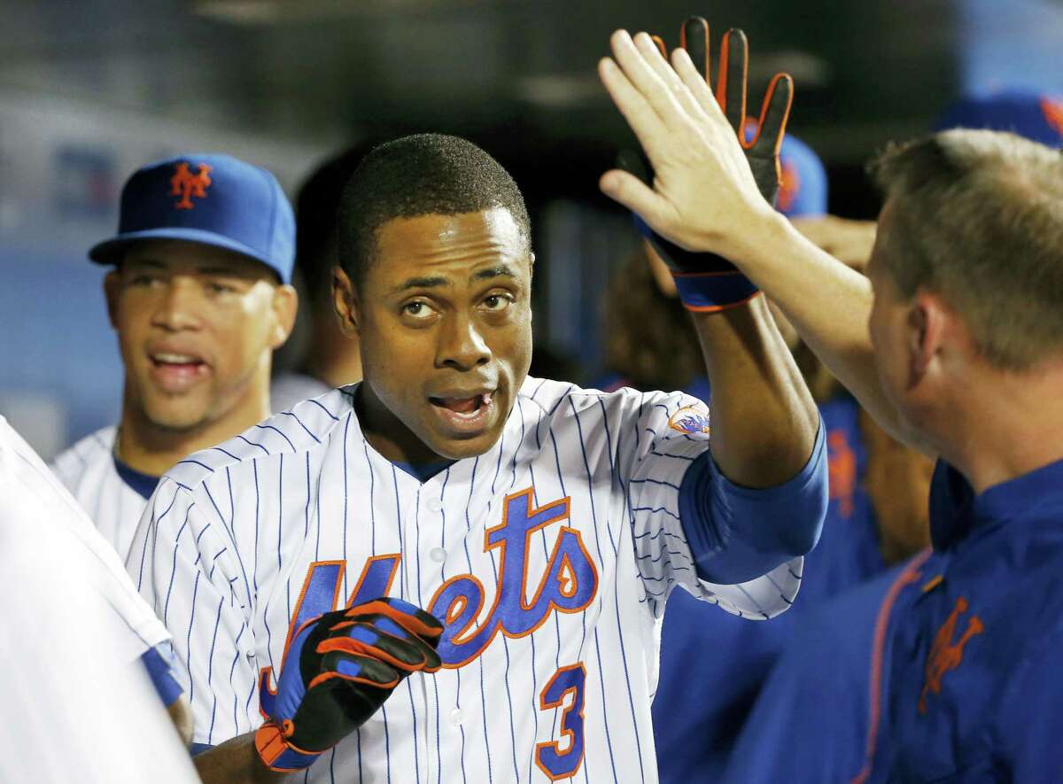 New York’s Curtis Granderson is congratulated in the dugout after he hit a two-run home run during the seventh inning against the Miami Marlins, Tuesday. Relief pitcher Hansel Robles is at left. Granderson homered twice and the Mets won 7-4.