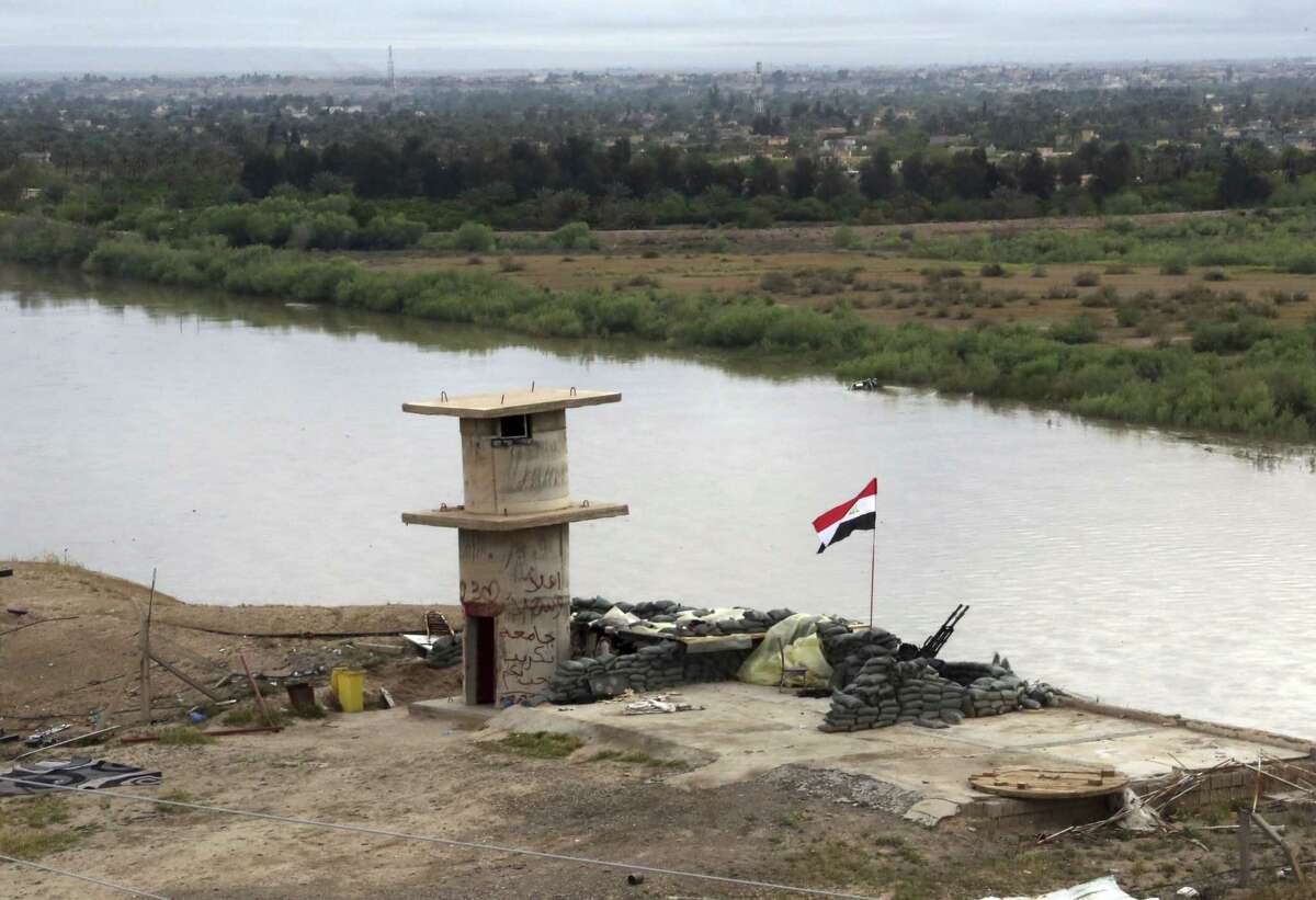An Iraqi flag waves over the Tigris River at a checkpoint in Tikrit, 80 miles (130 kilometers) north of Baghdad, Iraq, Wednesday, April 1, 2015. Iraqi security forces battled the last remaining pockets of Islamic State militants in Tikrit on Wednesday and were expected to gain full control of the city "within the coming hours," said Iraqi Interior Minister Mohammed Salem al-Ghabban. (AP Photo/Khalid Mohammed)