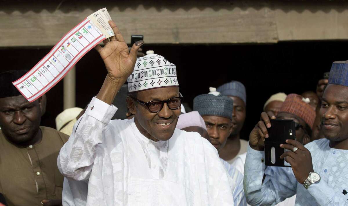 FILE - In this Saturday, March 28, 2015 file photo, opposition candidate Gen. Muhammadu Buhari holds his ballot paper in the air before casting his vote in his home town of Daura, northern Nigeria. On Tuesday, March 31, 2015 Nigeria's aviation minister said President Goodluck Jonathan had called challenger Muhammadu Buhari to concede and congratulate him on his electoral victory, paving the way for a peaceful transfer of power in Africa's richest and most populous nation. (AP Photo/Ben Curtis, File)