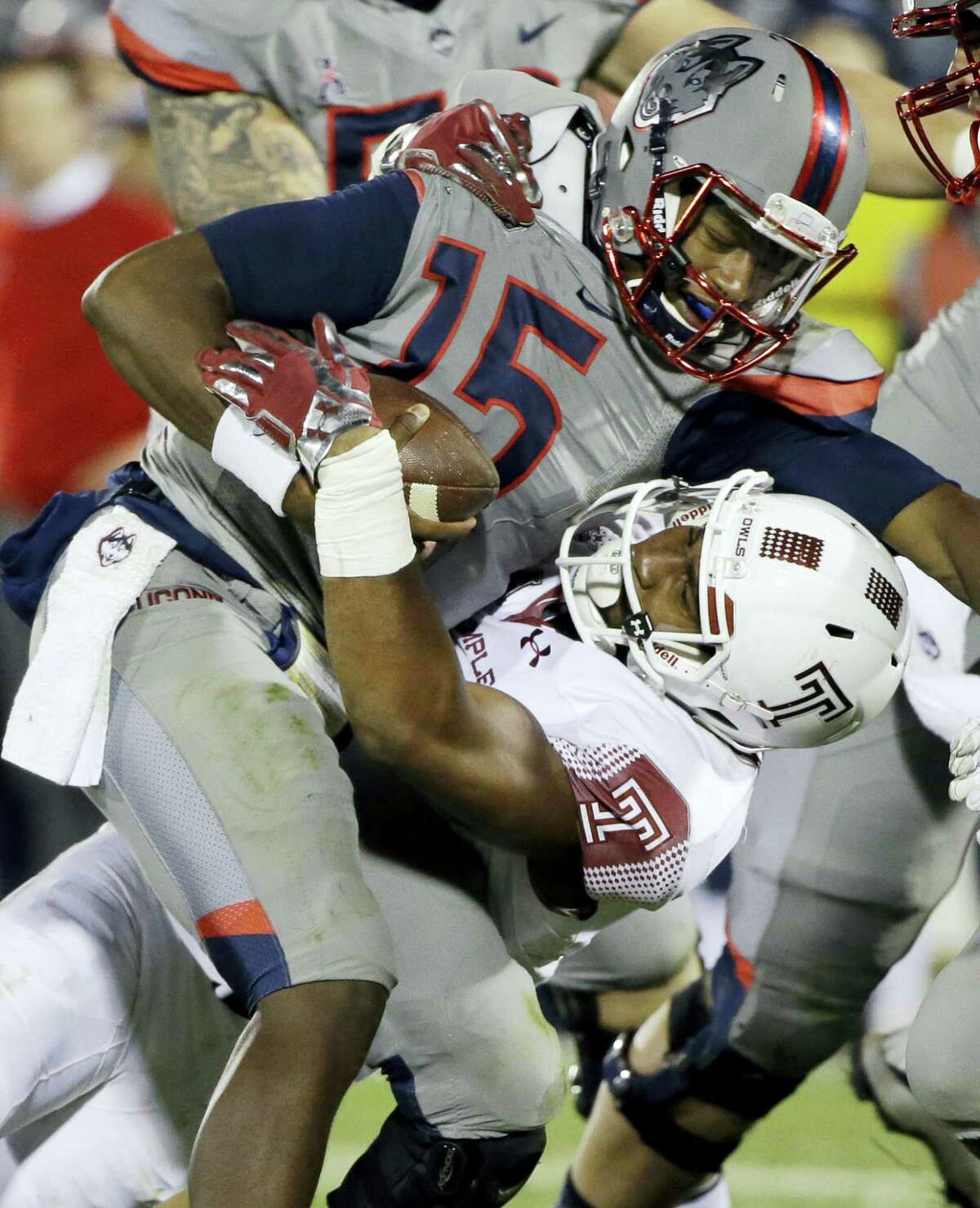 UConn quarterback Donovan Williams is brought down by Temple defensive lineman Haason Reddick during Friday night’s game.