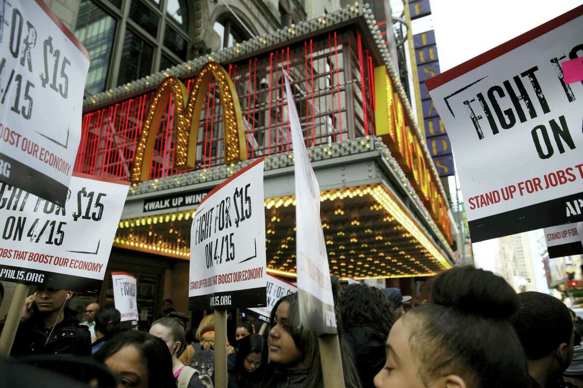 In this March 31, 2015 photo, people participate in a rally in front of a McDonald’s restaurant in New York. Protesters calling for pay of $15 an hour and a union will be at McDonald’s stores around the country and overseas on Thursday, April 14, 2016 as part of an ongoing push targeting the world’s biggest hamburger chain.