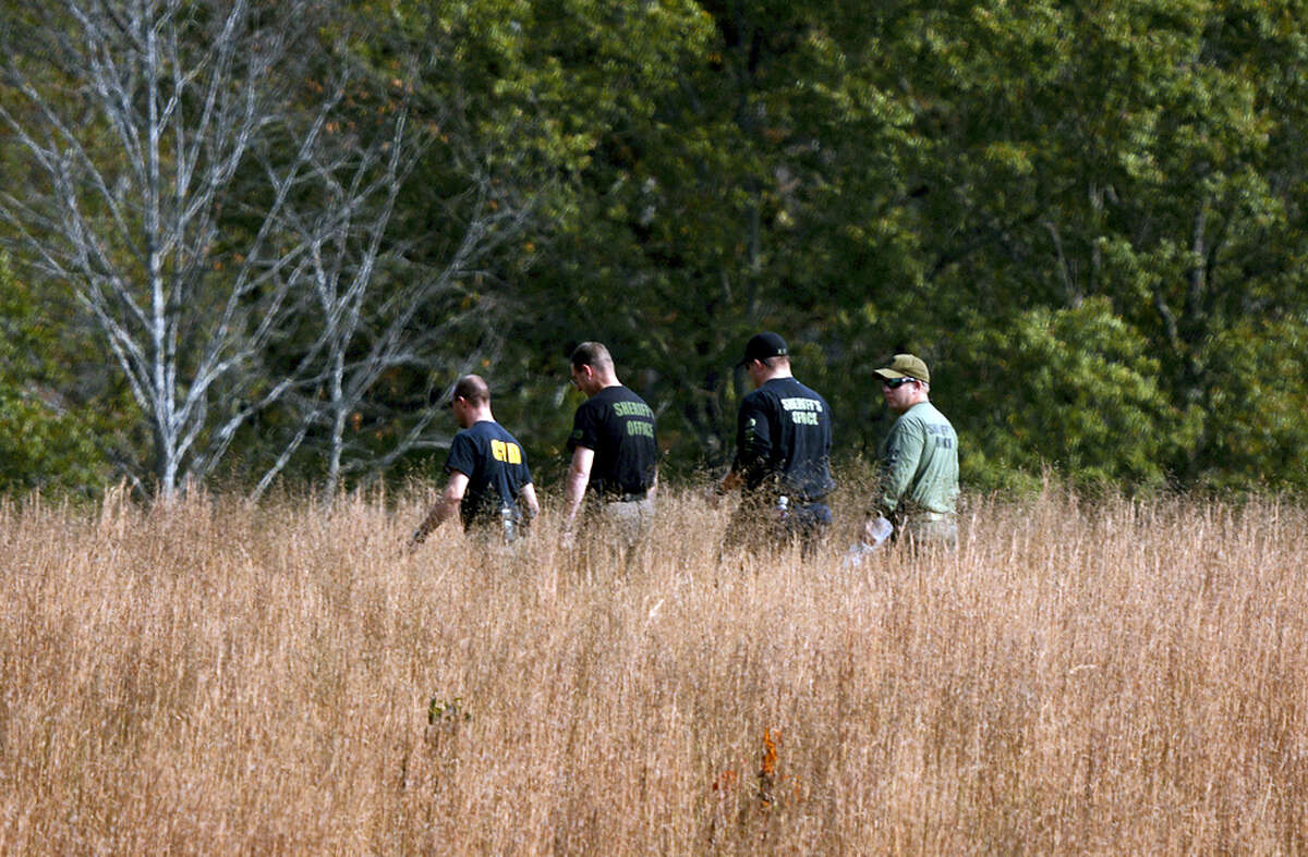 In this Thursday, Nov. 3, 2016, photo, police search a field on property owned by Todd Kohlhepp where a missing woman was found chained up in a large storage container in Woodruff, S.C.