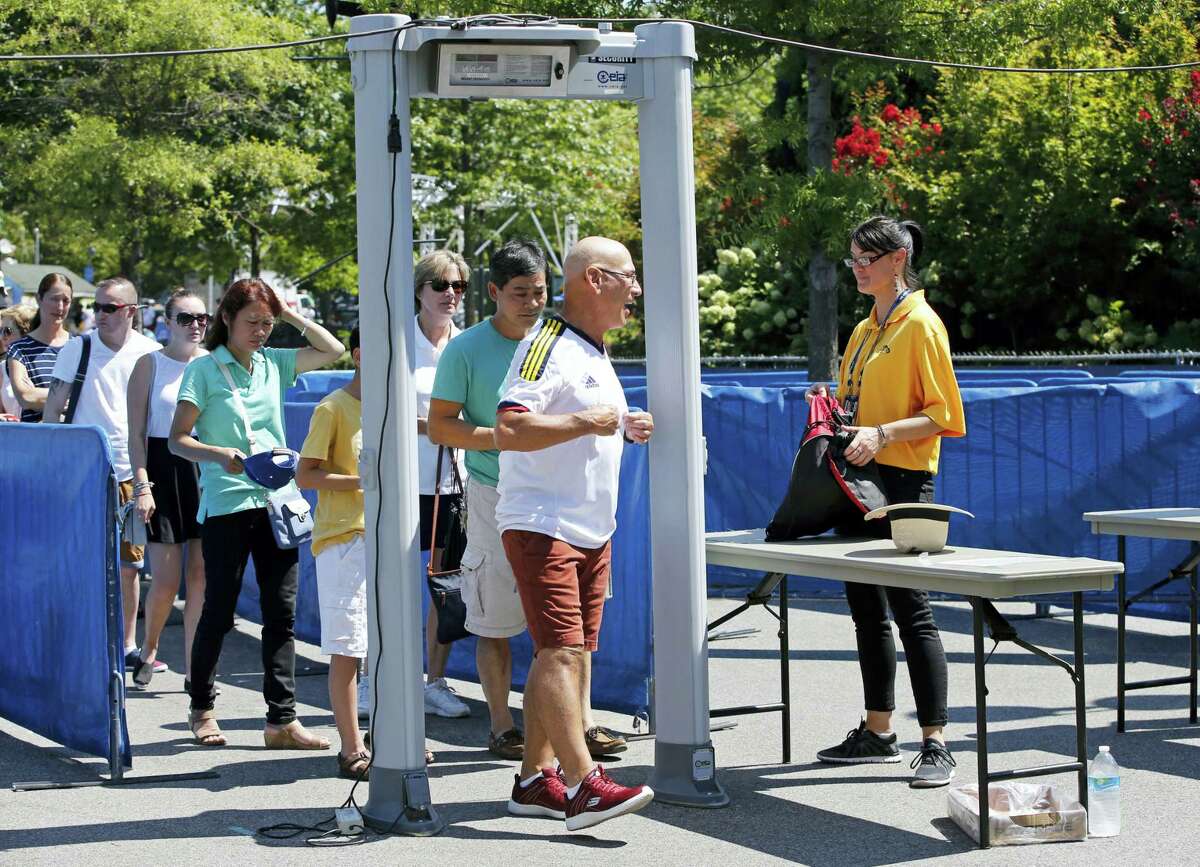 Spectators go through a metal detector while entering the Billie Jean King National Tennis Center, site of the U.S. Open Tennis Tournament in New York.