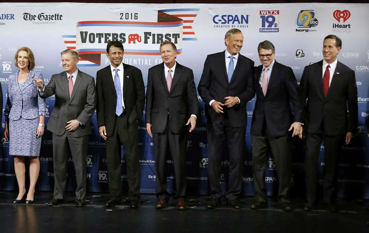 Republican presidential candidates gather on stage before a forum Monday, Aug. 3, 2015, in Manchester, N.H. From left: businesswoman Carly Fiorina, Sen. Lindsey Graham, R-S.C., Louisiana Gov. Bobby Jindal, Ohio Gov. John Kasich, former New York Gov. George Pataki, former Texas Gov. Rick Perry, and former Pennsylvania Sen. Rick Santorum.