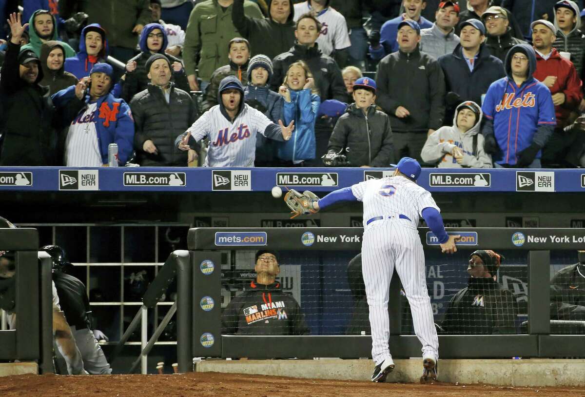 Marlins manager Don Mattingly, bottom center, watches from the dugout as Mets third baseman David Wright (5) tries to catch an eighth-inning foul ball on Tuesday. Wright couldn’t make the play and the ball bounced into the stands.