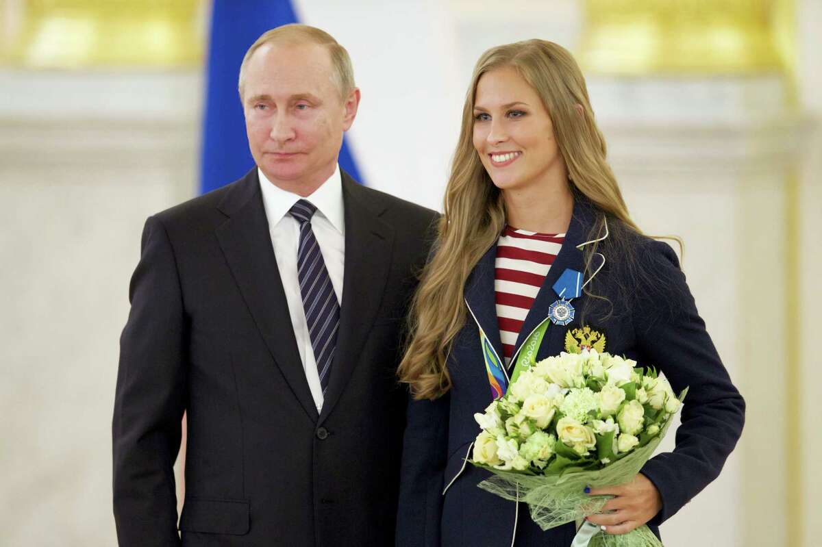 Russian President Vladimir Putin, left, poses with Alla Shishkina, who won her synchronised swimming team gold medal in Rio.