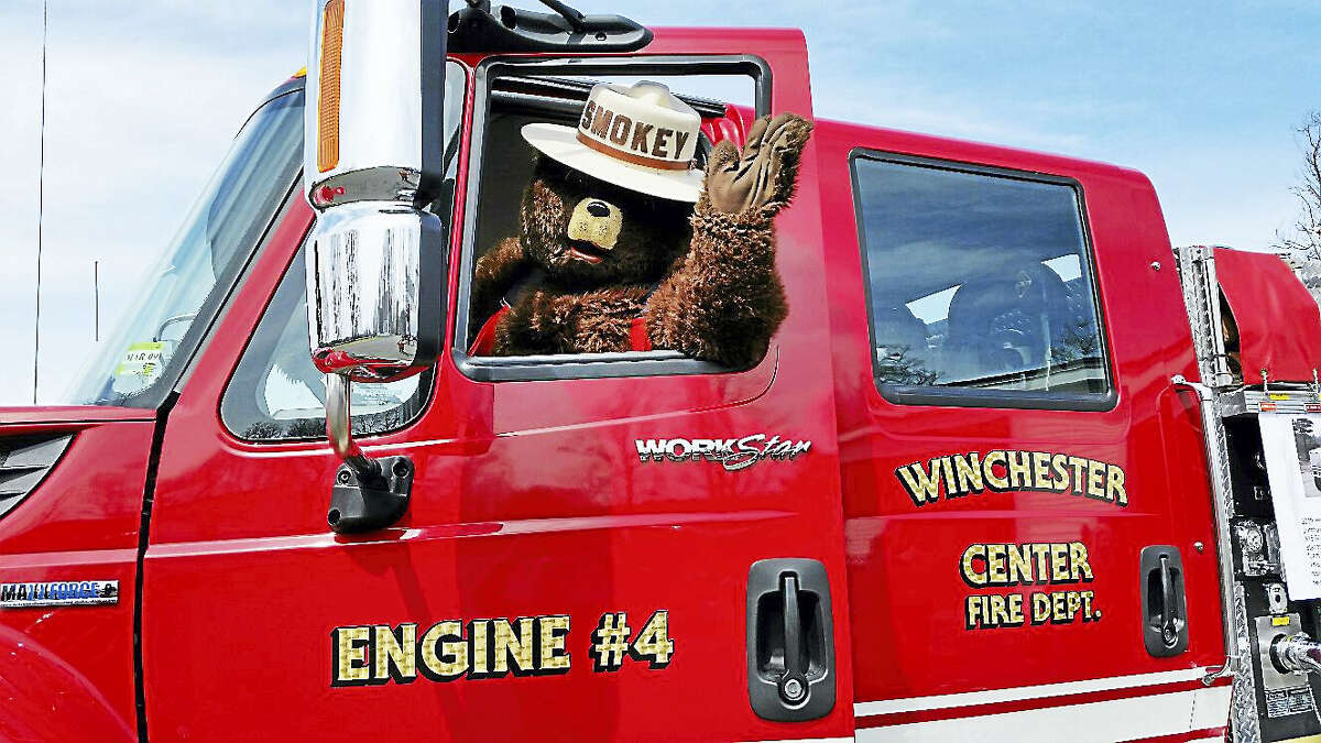 N.F. Ambery photo Firefighting mascot Smokey the Bear sat behind the wheel of a fire truck, preparing to receive visitors.