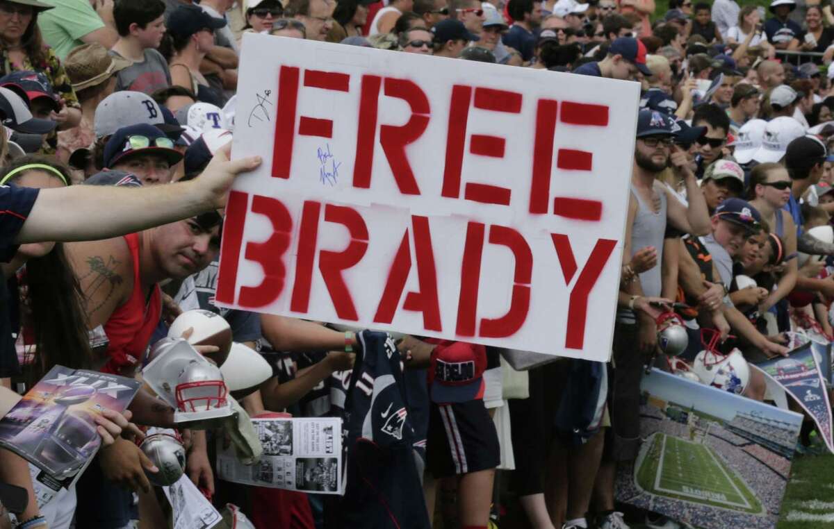 A New England Patriots fan holds a "Free Brady" sign during an NFL football training camp in Foxborough, Mass., Thursday, July 30, 2015. (AP Photo/Charles Krupa)