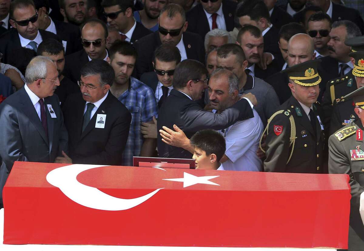Turkey’s Prime Minister Ahmet Davutoglu, centre, embraces the father, name not available, of late Turkish soldier Hamza Yildirim, next to his Turkish flag-draped coffin during the funeral ceremony at Kocatepe Mosque in Ankara, Turkey on July 31, 2015. Yildirim was one of the three Turkish troops that were killed on July 30 when Kurdistan Workers’ Party, or PKK militants opened fire on their convoy in the southeastern province of Sirnak, according to the army.