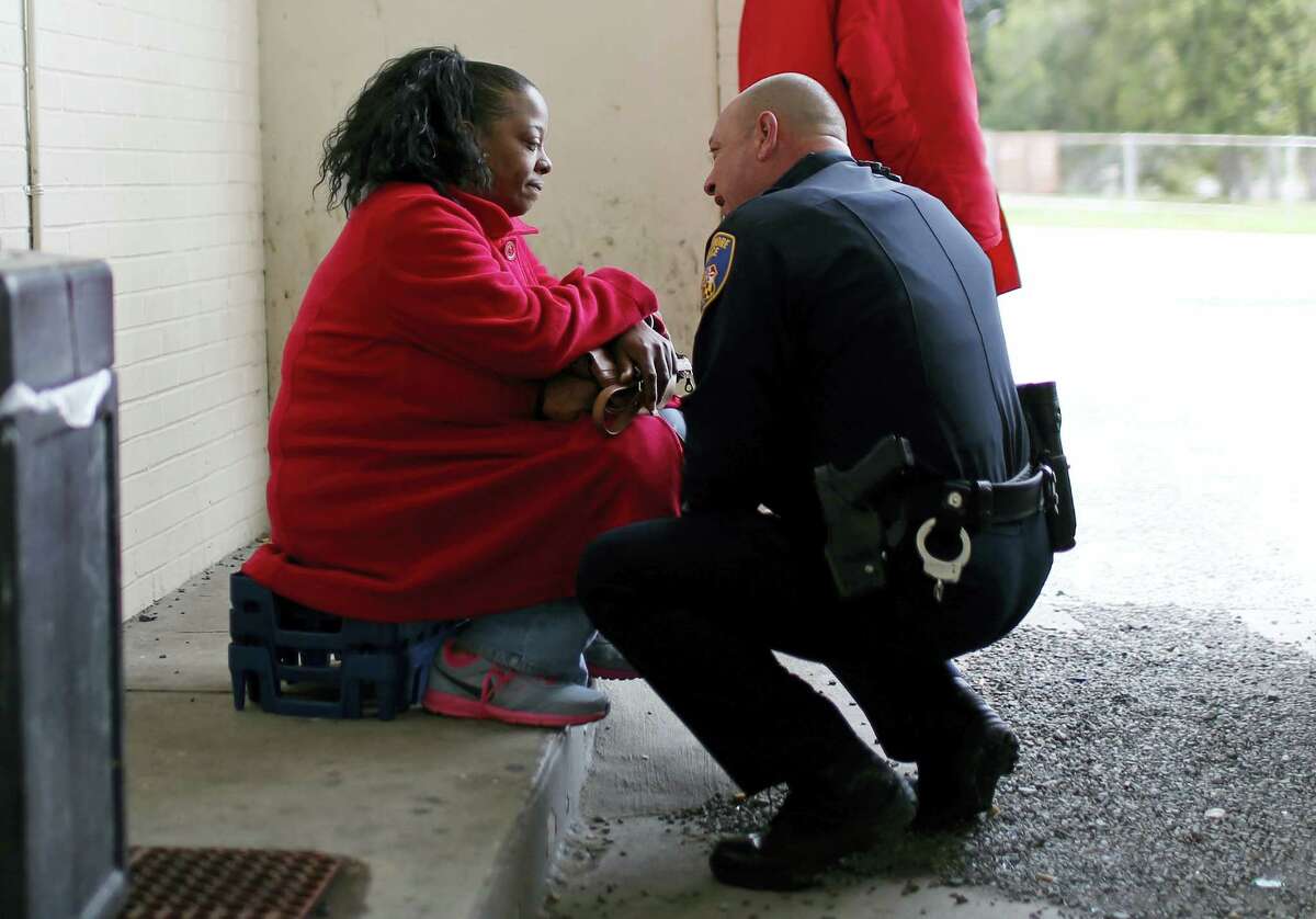 In this April 8, 2016 photo, Baltimore Police Department Officer Ken Hurst, right, consoles Rosa Brown, who was expressing suicidal thoughts following the recent death of her son, during his foot patrol in Baltimore. Hurst is one of 450 police officers who are part of a foot patrol program aimed at getting police officers out of their cars and onto the streets of Baltimore’s most dangerous neighborhoods, not to make arrests but to make friends.