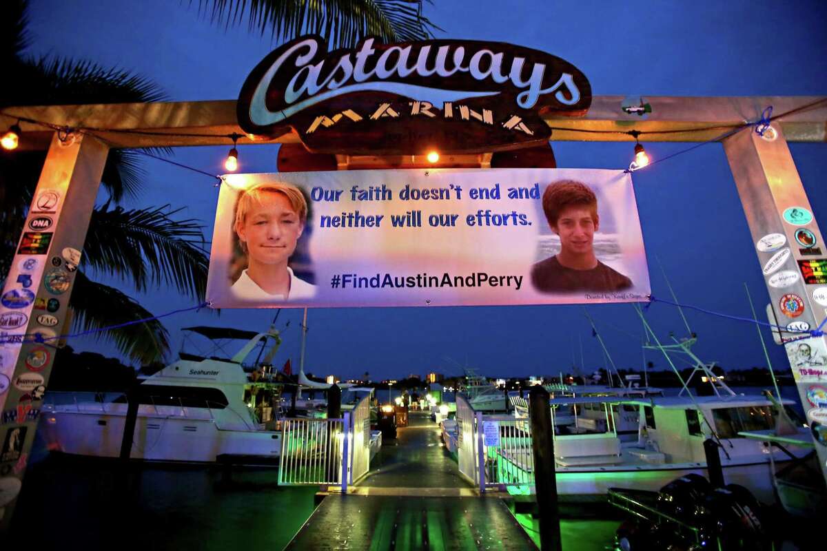 A banner hangs at the Castaways Marina with pictures of Austin Stephanos and Perry Cohen. After 8 days of searching the ocean, the U.S. Coast Guard ended their search for the boys. Friends and relatives attended a fundraiser at the Square Grouper, Friday in Jupiter, Fla.