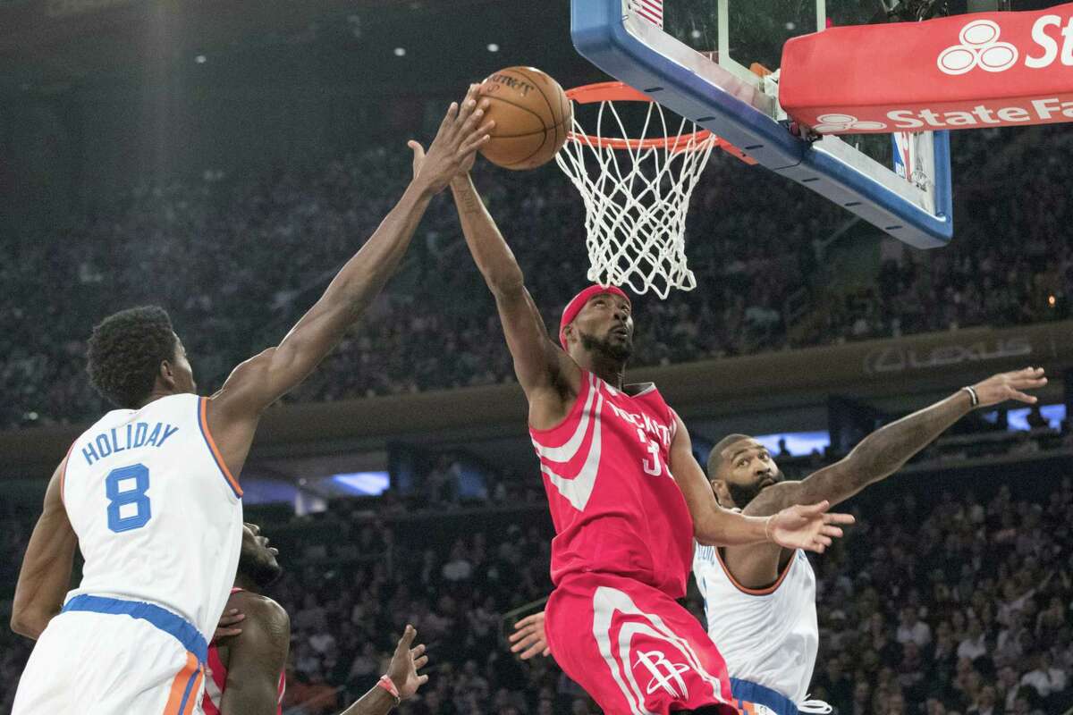 Houston Rockets forward Corey Brewer (33) goes to the basket past New York Knicks guards Justin Holiday (8) and Brandon Jennings during the first half at Madison Square Garden in New York. The Rockets won 118-99.