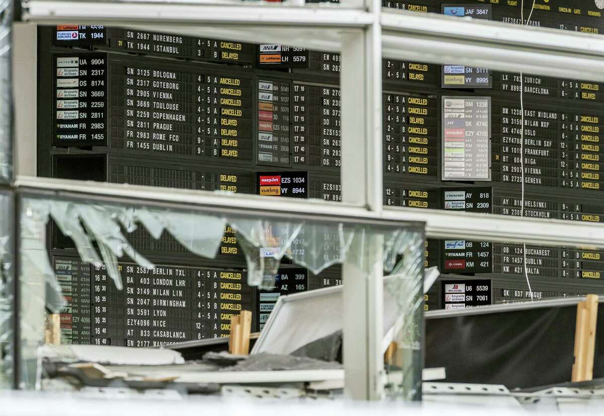 This March 23, 2016 file photo, shows an arrivals and departure board behind blown out windows at Zaventem Airport in Brussels. The airport plans to partially reopen Sunday, April 3, 2016, but the limited number of flights by Brussels Airlines following a 12-day shutdown is meant to be largely symbolic. The airport plans to be back up to 20 percent of capacity by Monday.