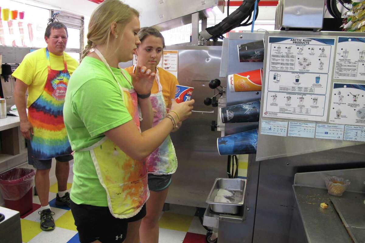 Kristin Drechsel, foreground, gives Madison Brenamen tips on making a Blizzard at the Dairy Queen in downtown Moorhead, Minn., while store owner Troy DeLeon looks on.