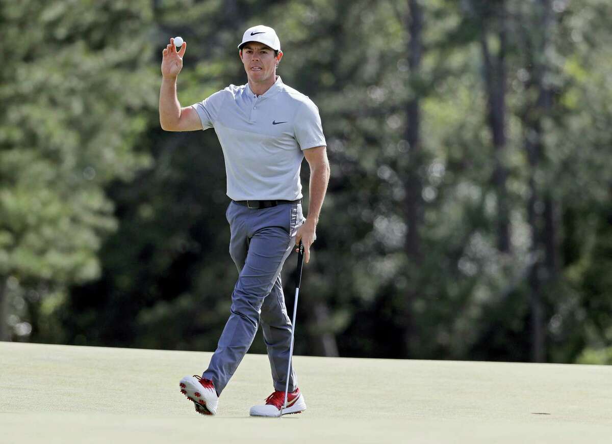 Rory McIlroy holds up his ball after putting out on the 18th hole.