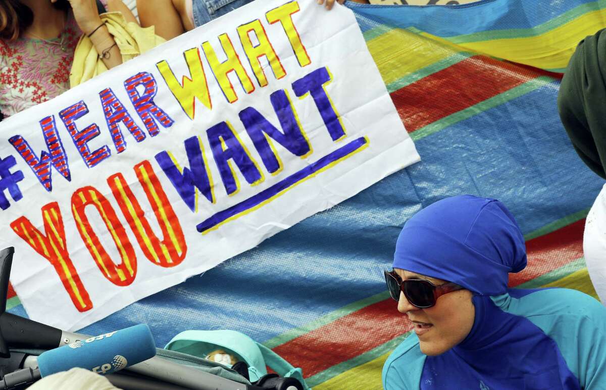 An activist protests outside the French embassy during, the “wear what you want beach party” in London Thursday. The protest is against the French authorities clampdown on Muslim women wearing burkinis on the beach.