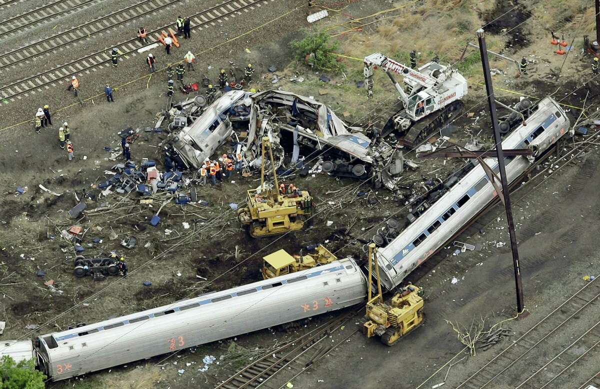 In this Wednesday, May 13, 2015 photo, emergency personnel work at the scene of a derailment in Philadelphia of an Amtrak train headed to New York. Many commuter and freight railroads have made little progress installing safety technology designed to prevent deadly collisions and derailments despite a mandate from Congress, according to a government report released Aug. 17, 2016.