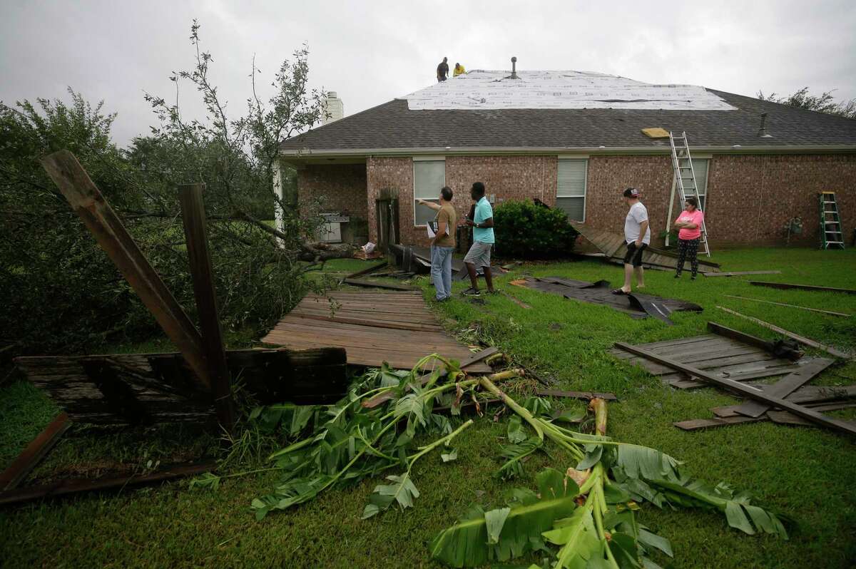 People look at tornado damage from Hurricane Harvey in the Lone Oak subdivision Saturday, Aug. 26, 2017, in Cypress.