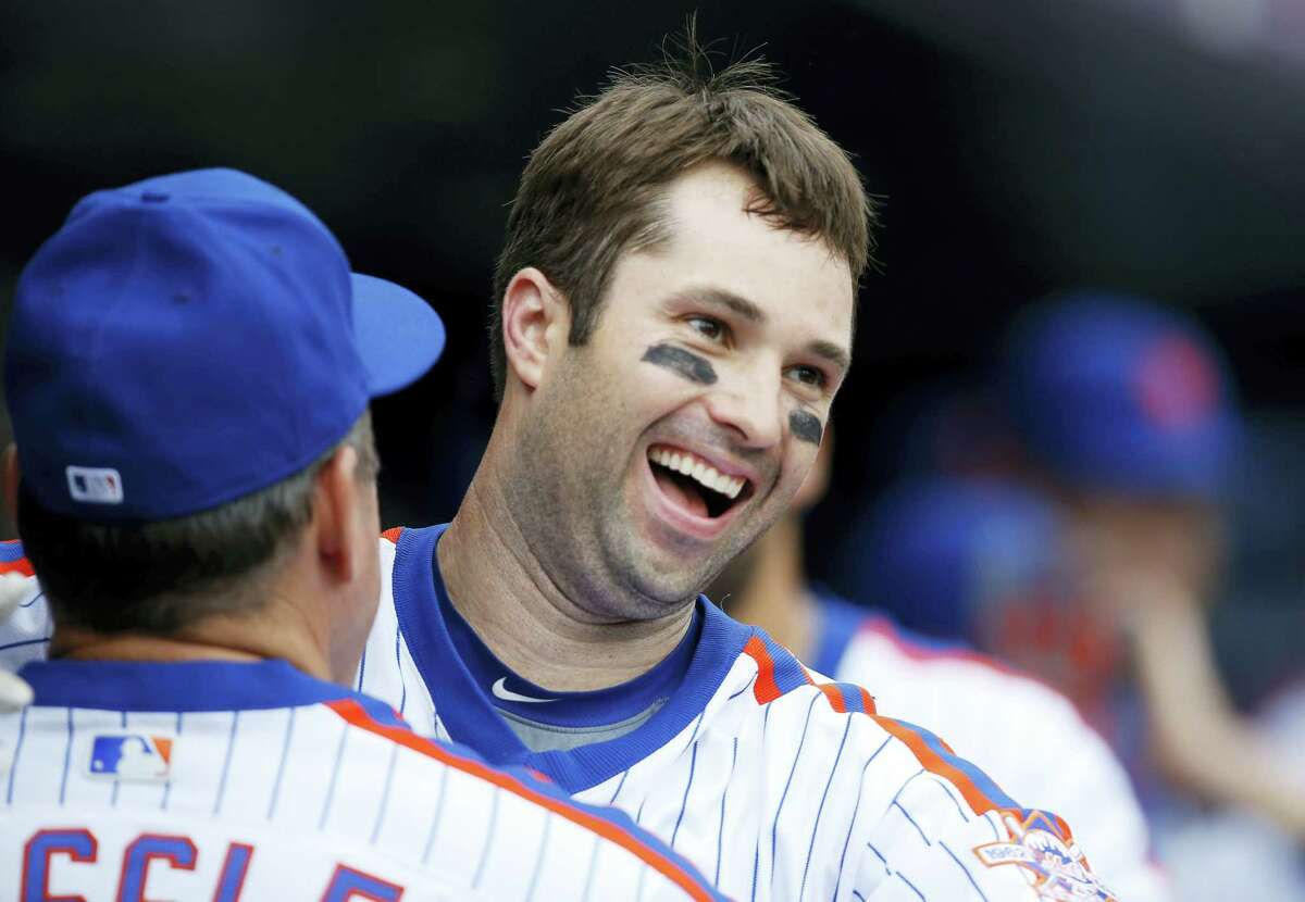 New York Mets second baseman Neil Walker (20) reacts with a coach in the dugout after hitting a go-ahead, three-run home run during the seventh inning of a baseball game against the Colorado Rockies, Sunday, July 31, 2016, in New York. (AP Photo/Kathy Willens)