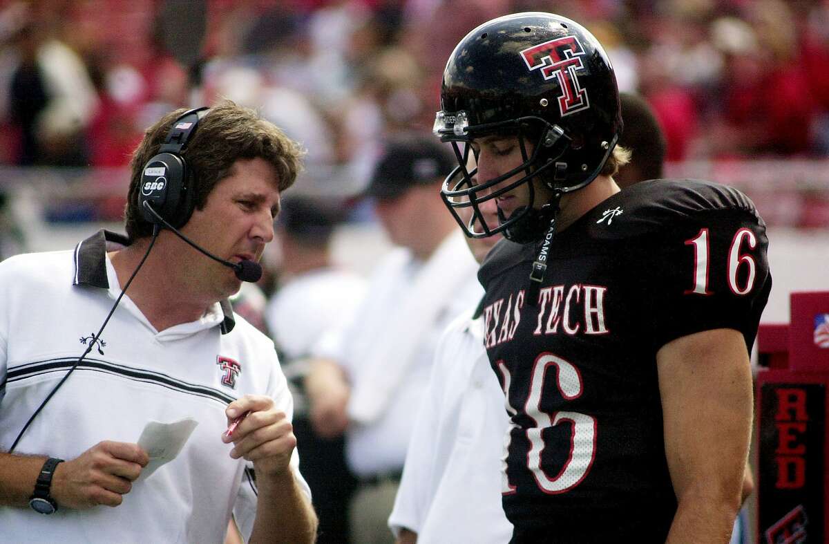 Texas Tech football coach Mike Leach, left, talks to quarterback Kliff Kingsbury during the game against Mississippi on Sept. 14, 2002, in Lubbock, Texas.
