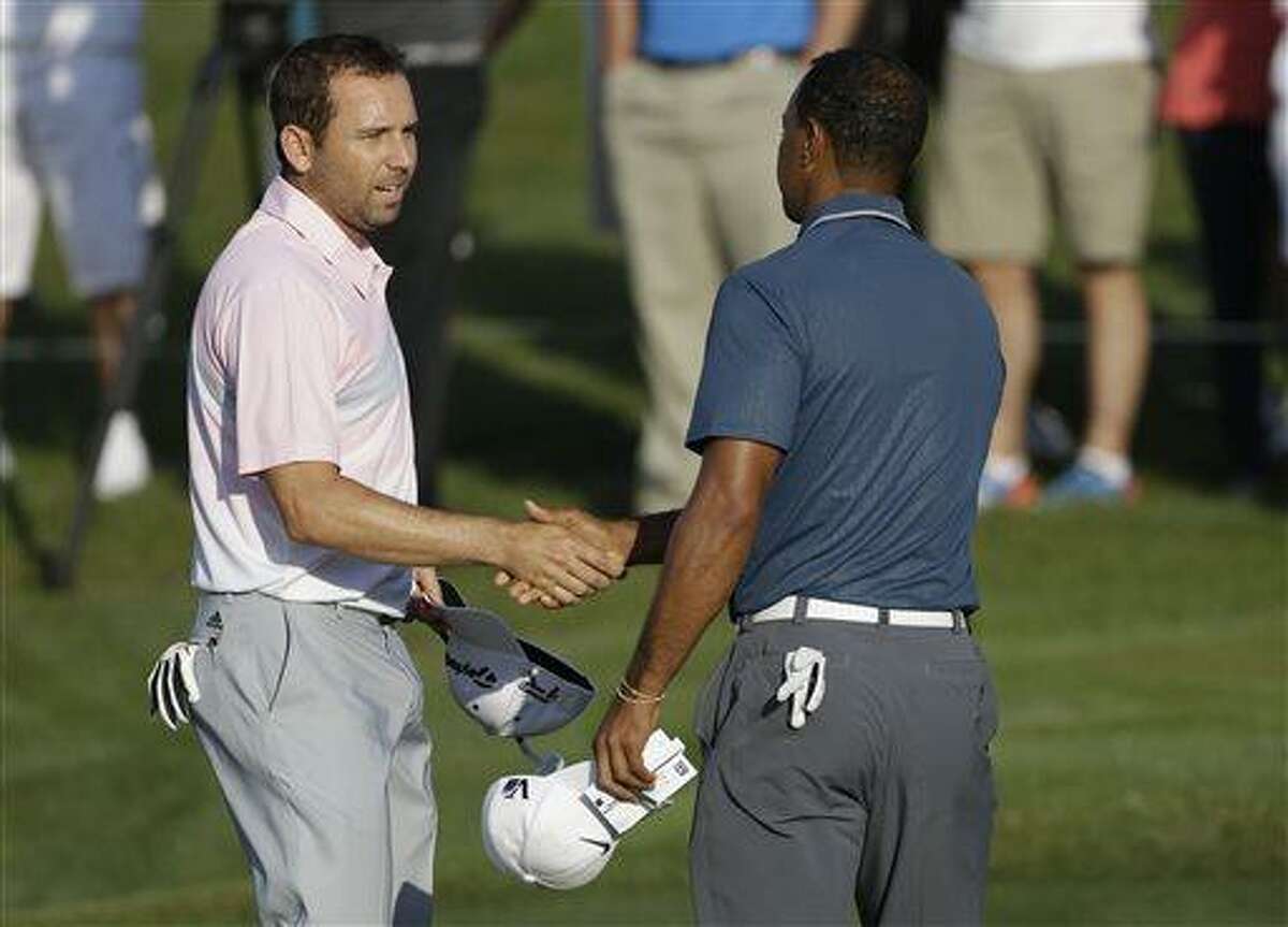 In this photo made May 12, 2013, Sergio Garcia, of Spain, left, shakes hands with Tiger Woods at the end of the third round of The Players championship golf tournament at TPC Sawgrass in Ponte Vedra Beach, Fla. Garcia apologized to Woods on Wednesday, May 22, 3013, for saying he would have "fried chicken" at dinner with his rival, a comment that Woods described as hurtful and inappropriate. (AP Photo/Gerald Herbert)