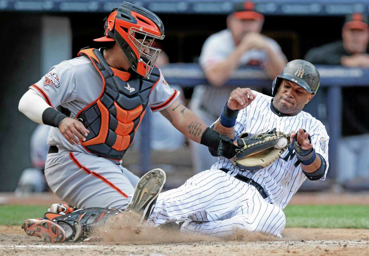 Giants catcher Hector Sanchez tags out the Yankees’ Robinson Cano at the plate after Eduardo Nunez hit into an eighth-inning fielder’s choice for the third out Sunday.
