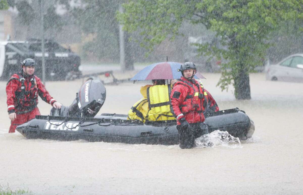 Rescuers pull a boat to take people to be transferred at a pickup point along Edgebrook Sunday, August 27, 2017.