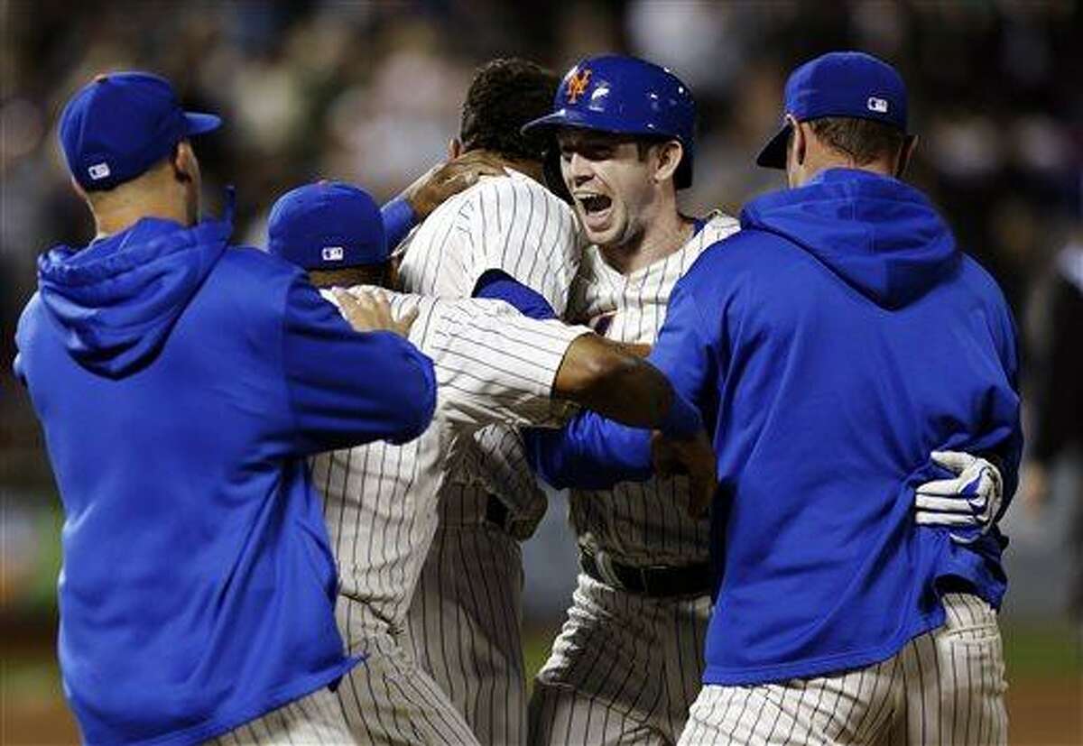 New York Mets' Mike Baxter, second from right, reacts as teammates mob him following his walk-off single during the 10th inning of the baseball game against the Chicago White Sox at Citi Field Tuesday, May 7, 2013 in New York. The Mets defeated the White Sox 1-0. (AP Photo/Seth Wenig)