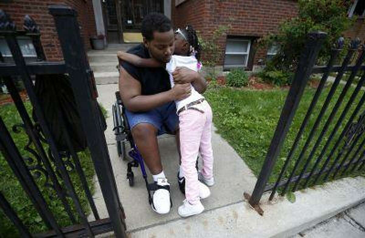 Miles Turner gets a hug from his cousin Sophia White at his home in Chicago, Illinois, June 9, 2013.