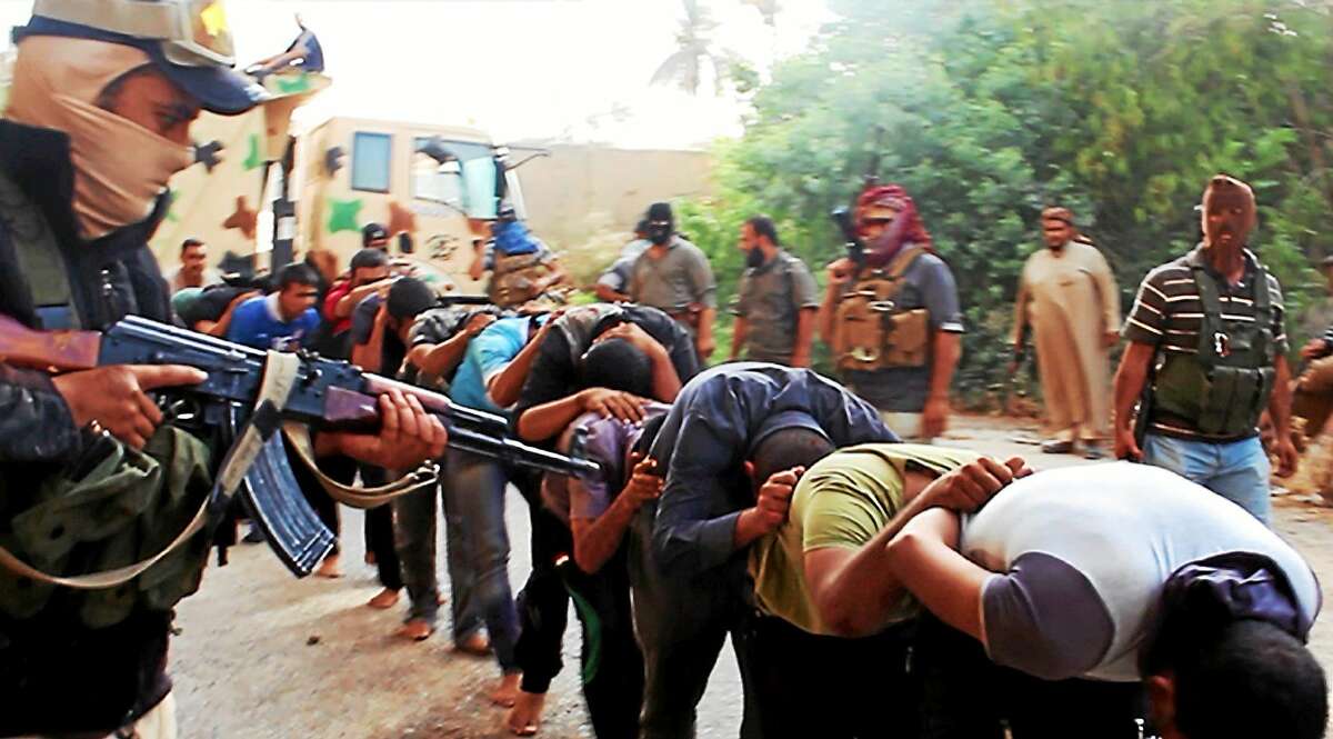 This June 14, 2014 file image posted on a militant website which has been verified and is consistent with other AP reporting, appears to show militants from the Islamic State group leading away captured Iraqi soldiers dressed in plain clothes after taking over a base in Tikrit, Iraq. The Islamic State group is richer than al-Qaida, operates a modern, effective media arm and holds much more territory than al-Qaida ever did.