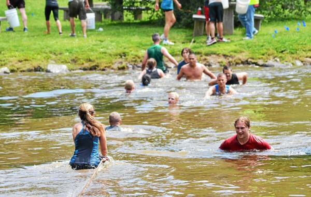 Runners cross the pond during the 5k WYLD Mud Run at the John A Minetto State Park on Saturday. The event is a fundraiser for the Northwest CT YMCA. John Berry - Register Citizen.