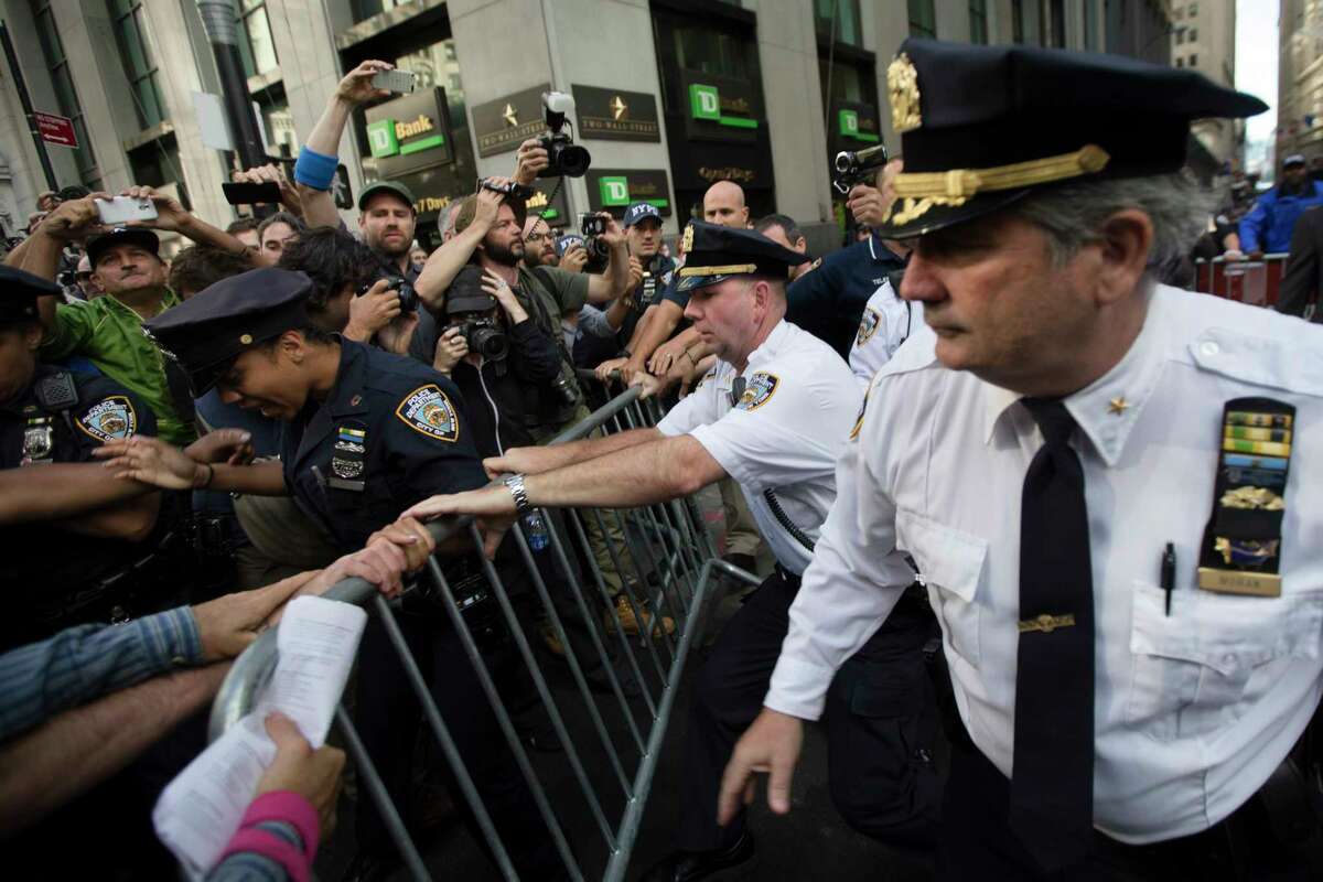Police move to secure a barricade being wrestled away by protestors during a march demanding action on climate change and corporate greed, Monday, Sept. 22, 2014, a day after a huge climate march in New York.