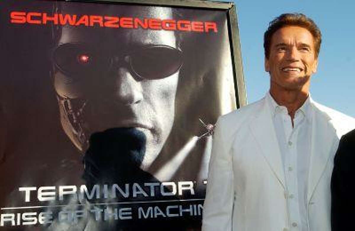 In this June 30, 2003 file photo, Arnold Schwarzenegger, star of the new film "Terminator 3: Rise of the Machines," is pictured next to the film's poster at the world premiere of the film in the Westwood section of Los Angeles. (AP Photo/Chris Pizzello)