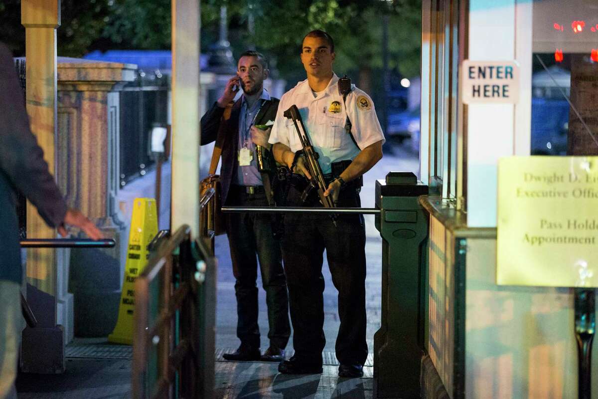 A Secret Service police officer holds a weapon as he stands near an entrance to the White House complex during an evacuation minutes after President Barack Obama departed Washington for Camp David aboard Marine One on Sept. 19, 2014. A Secret Service agent at the scene says someone jumped the fence surrounding the White House.