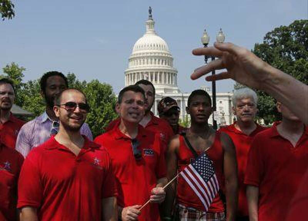 With the Capitol in the background, the Gay Men's Choir of Washington, D.C. performs in front of the Supreme Court in Washington, Wednesday, June 26, 2013. In a major victory for gay rights, the Supreme Court on Wednesday struck down a provision of a federal law denying federal benefits to married gay couples and cleared the way for the resumption of same-sex marriage in California. (AP Photo/Charles Dharapak)