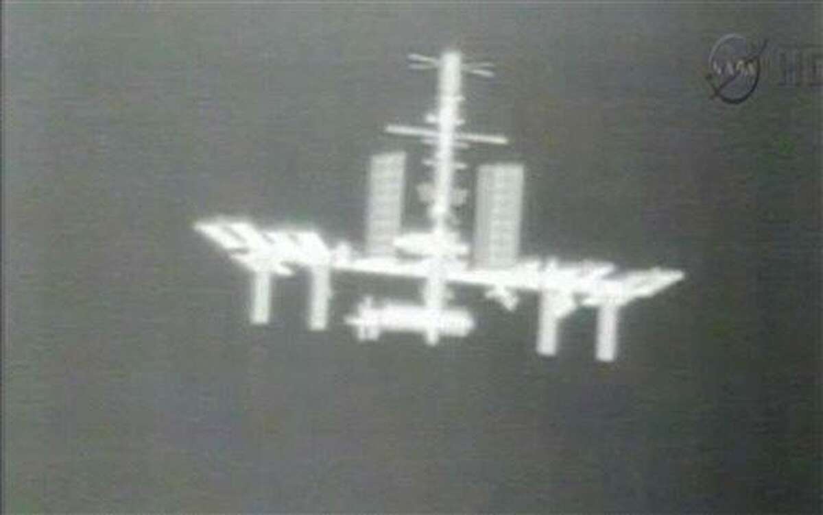 FILE - This Thursday, May 24, 2012 image made from video provided by NASA-TV shows the International Space Station taken from the thermal imaging camera aboard the SpaceX Dragon commercial cargo craft as it approaches the station. NASA says the International Space Station has lost contact with NASA controllers in Houston Tuesday morning, Feb. 19, 2013. Officials say the six crew members and station are fine and they expect to fix the problem soon. NASA said something went wrong during a computer software update on the station. (AP Photo/NASA)