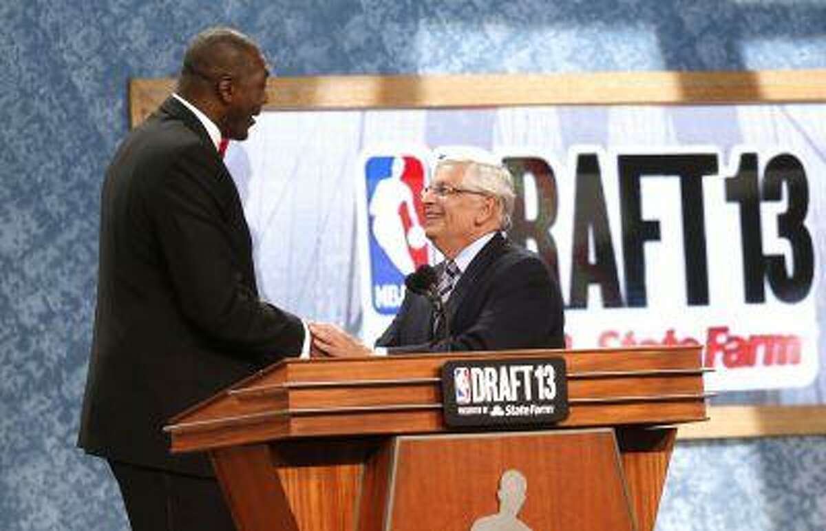 Retired NBA star Hakeem Olajuwan, left, shakes hands with NBA Commissioner David Stern after coming onstage to pay tribute to him at the end of the first round of the NBA basketball draft, Thursday, June 27, 2013, in New York.