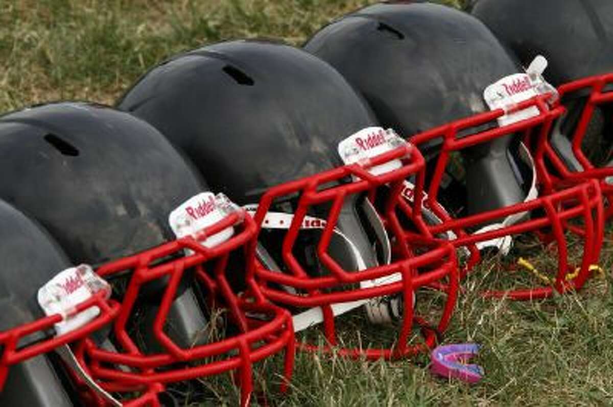 FILE - This Aug. 4, 2012 file photo shows new football helmets that were given to a group of youth football players from the Akron Parents Pee Wee Football League, in Akron, Ohio.