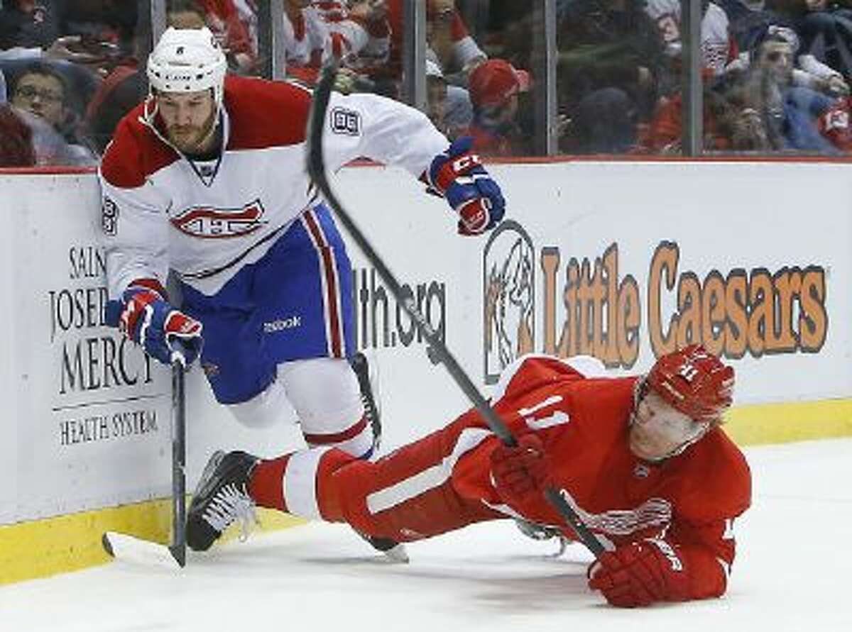 Detroit Red Wings right wing Daniel Alfredsson (11), of Sweden, is taken down by Montreal Canadiens right wing Brandon Prust (8) during a game Jan. 24 in Detroit.