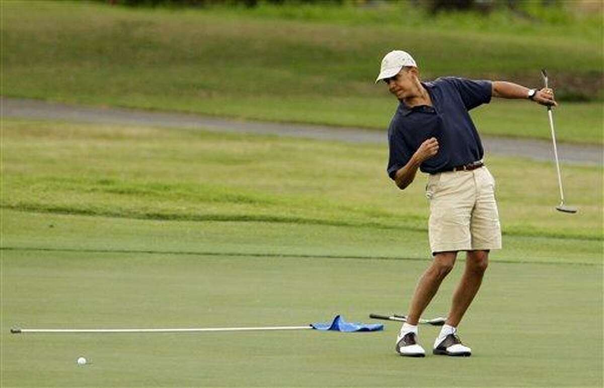 , President Barack Obama watches the ball after making a putt on the ninth green during his golf match at Mid-Pacific County Club in Kailua, Hawaii. Obama played golf Sunday with Tiger Woods, the White House said Sunday. Once the sport's dominant player before his career was sidetracked by scandal, Woods joined Obama at the Floridian, a secluded and exclusive yacht and golf club on Florida's Treasure Coast where Obama is spending the long Presidents Day weekend. The two had met before, but Sunday was the first time they played together. AP Photo/Chris Carlson