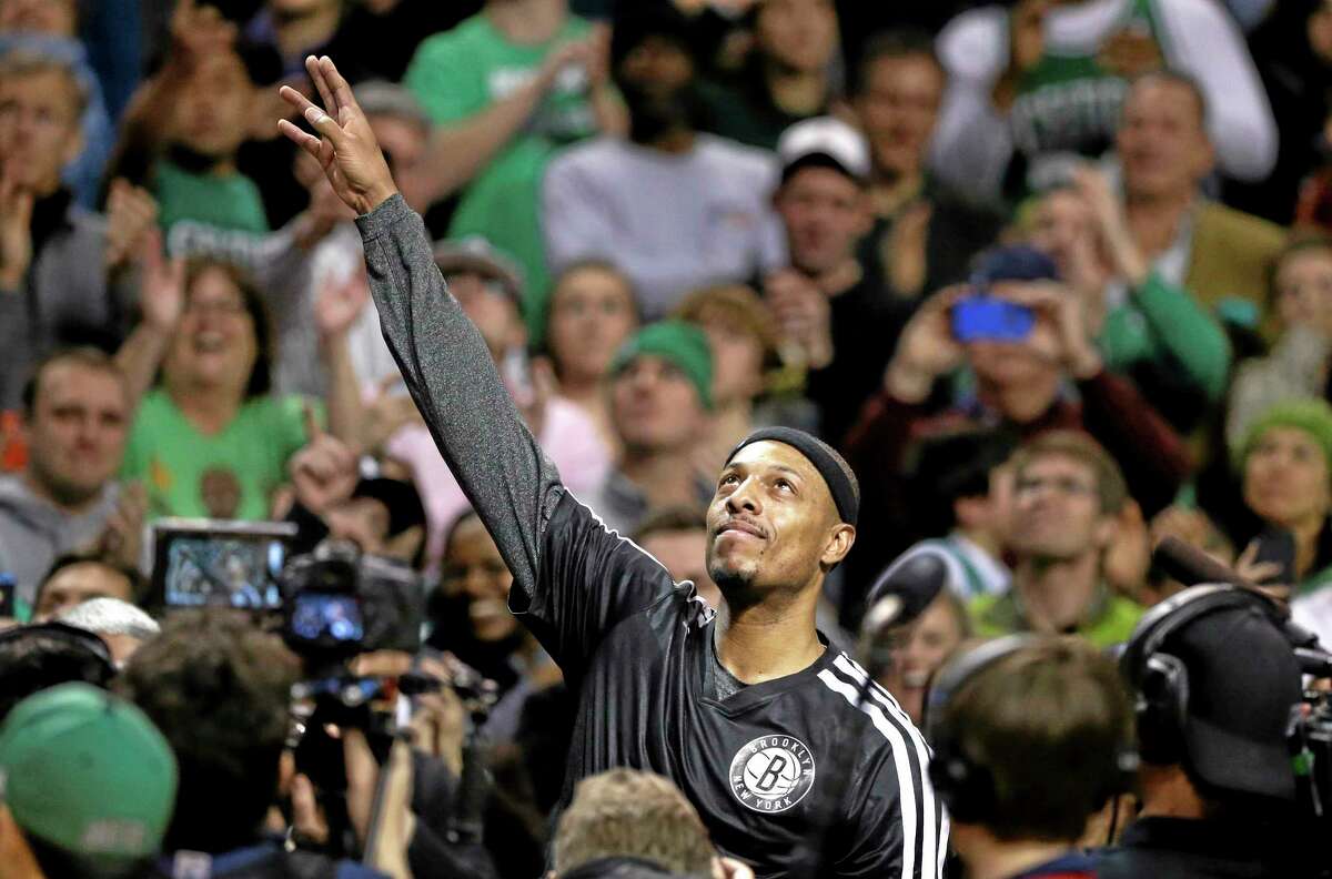 Brooklyn Nets forward Paul Pierce, center, formerly of the Boston Celtics, waves to the crowd during a tribute to him in an NBA basketball game against the Boston Celtics, Sunday, Jan. 26, 2014, in Boston. (AP Photo/Steven Senne)