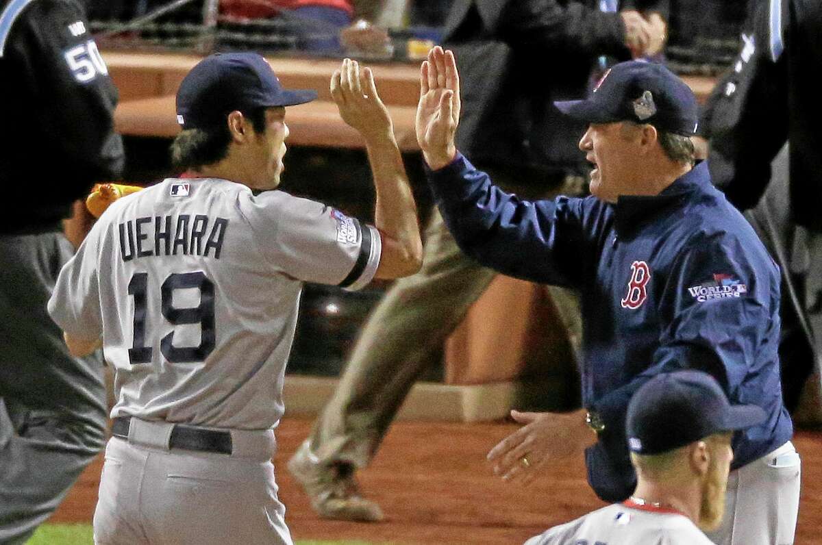 Boston Red Sox manager John Farrell congratulates relief pitcher Koji Uehara after Boston defeated the St. Louis Cardinals in Game 5 of the World Series 3-1 to take a 3-2 lead in the series.