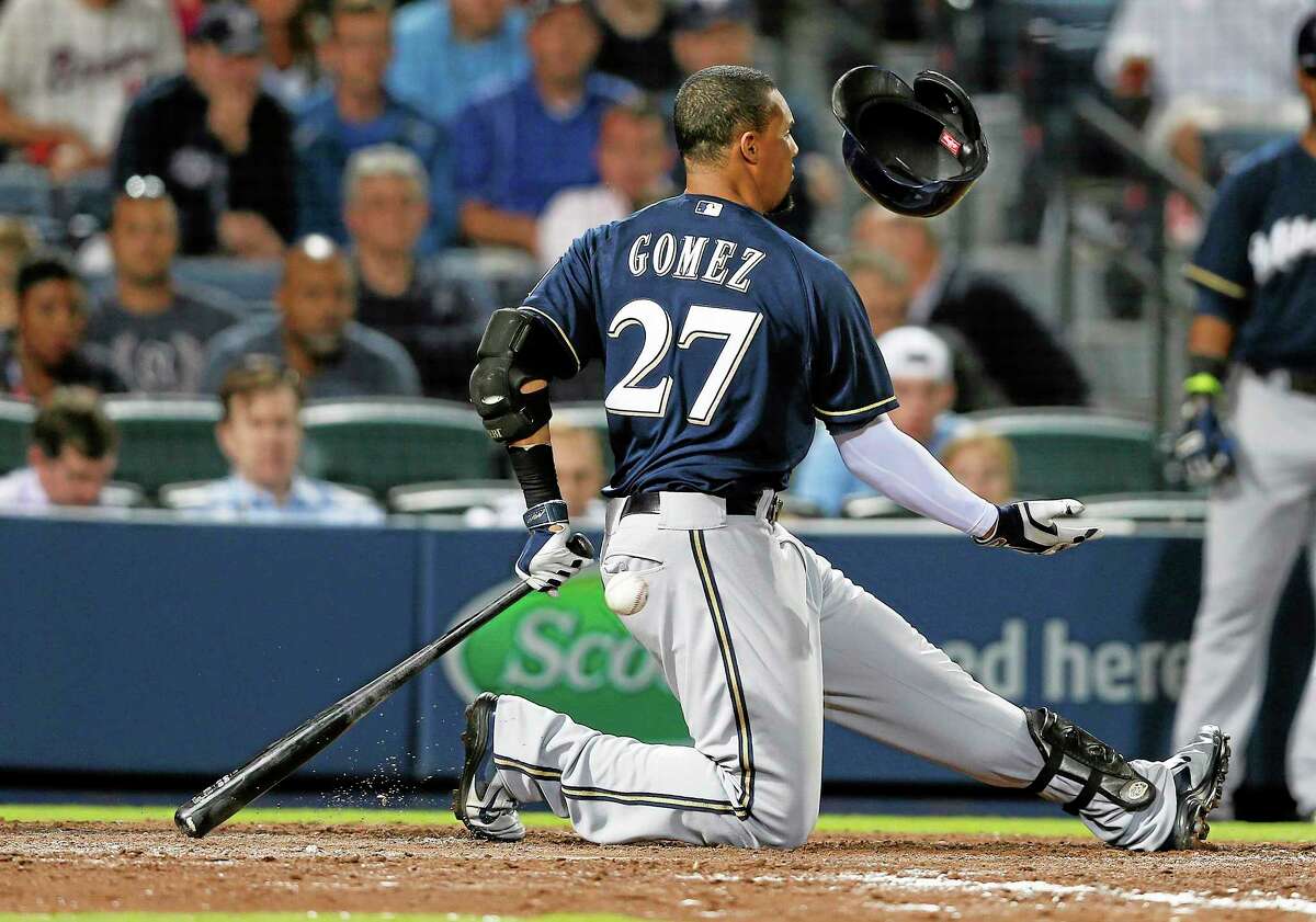 Milwaukee Brewers center fielder Carlos Gomez loses his helmet as he swings and misses during a game against the Braves on Monday in Atlanta.
