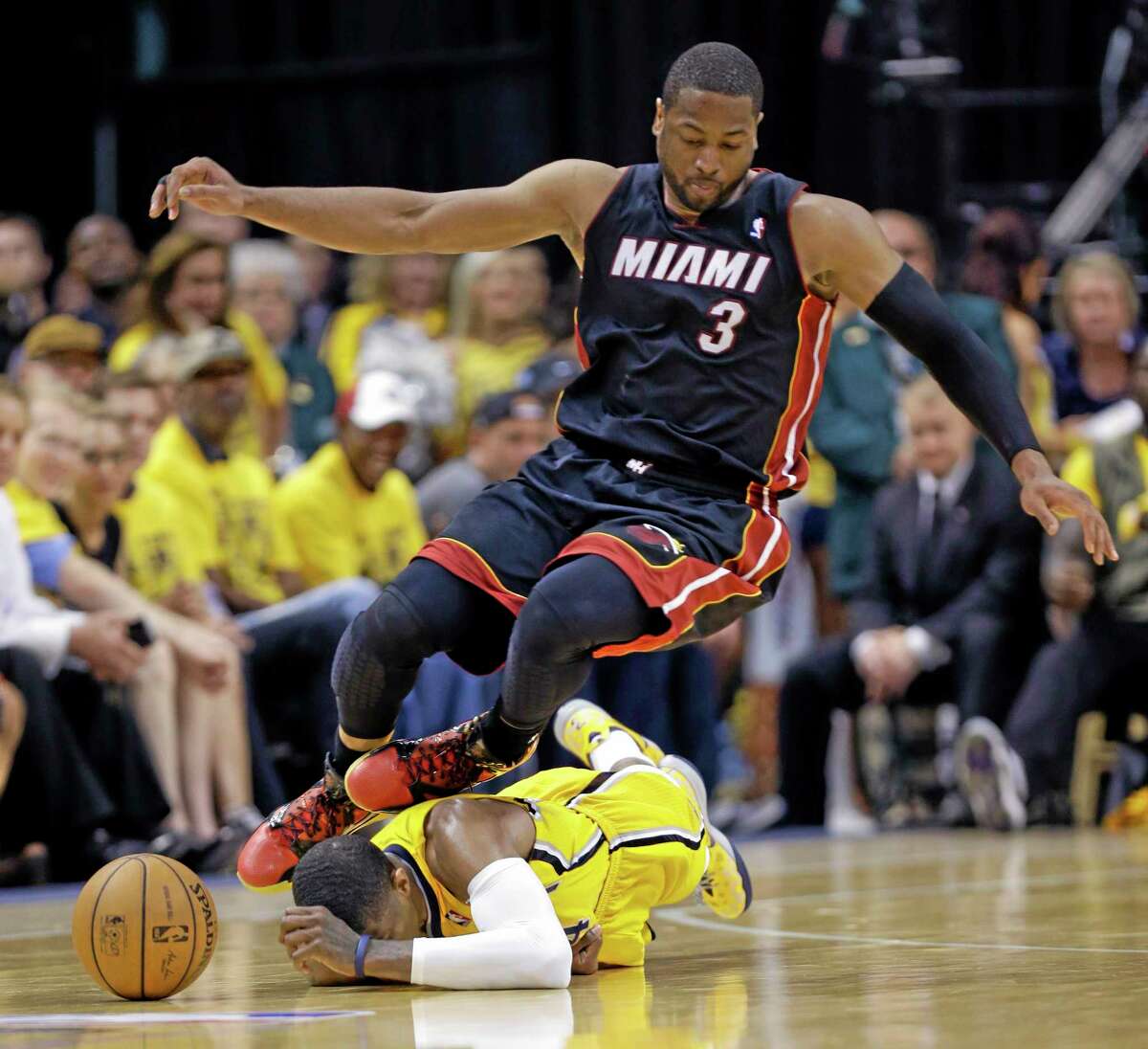 Miami Heat guard Dwyane Wade goes over Indiana Pacers forward Paul George as they go after a loose ball during the fourth quarter of Game 2 of the Eastern Conference finals Tuesday night in Indianapolis.