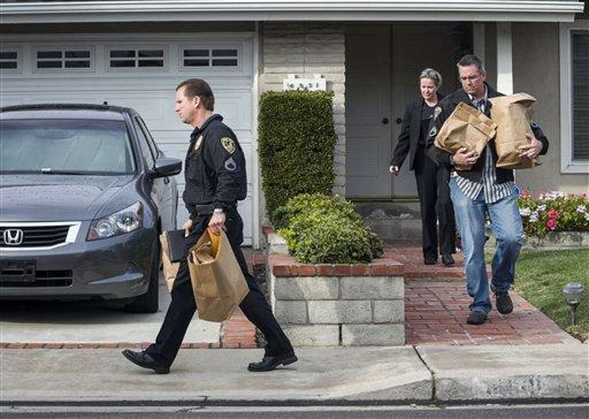 Police investigators take away evidence from the home of the mother of fugitive suspect former Los Angeles police officer Christopher Dorner, in La Palma, Calif. AP Photo/Damian Dovarganes