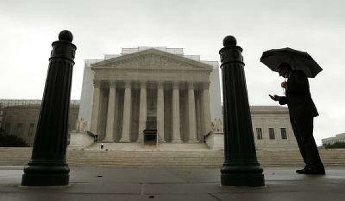 A man holds an umbrella outside the U..S. Supreme Court in Washington June 10, 2013.