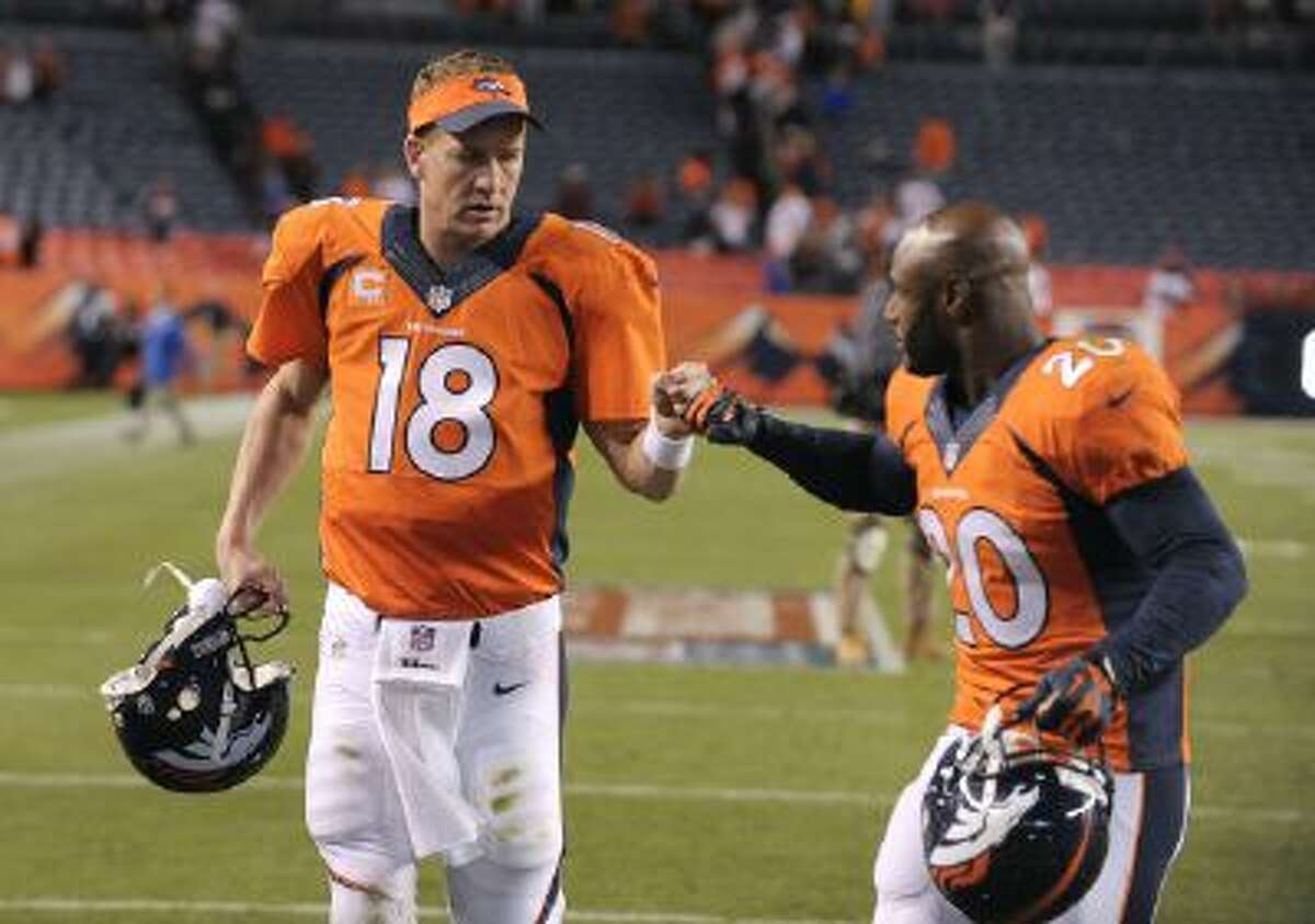 Denver Broncos quarterback Peyton Manning (18) bumps fists with strong safety Mike Adams (20) after beating the Oakland Raiders 37-21 in an NFL football game in Denver in September of 2013. Many thought his career was over at 37, with four surgical scars on his neck to match the four MVP awards in his trophy case, but a year later Denver's quarterback has led the Broncos to the Super Bowl and is in line for his fifth MVP award.