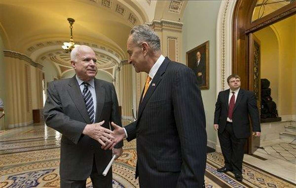 Sen. John McCain, R-Ariz., left, and Sen. Charles Schumer, D-N.Y., right, two of the authors of the immigration reform bill crafted by the Senate's bipartisan "Gang of Eight," shakes hands on Capitol Hill in Washington, Thursday, June 27, 2013, prior to the final vote. The historic legislation would dramatically remake the U.S. immigration system and require a tough new focus on border security. (AP Photo/J. Scott Applewhite)